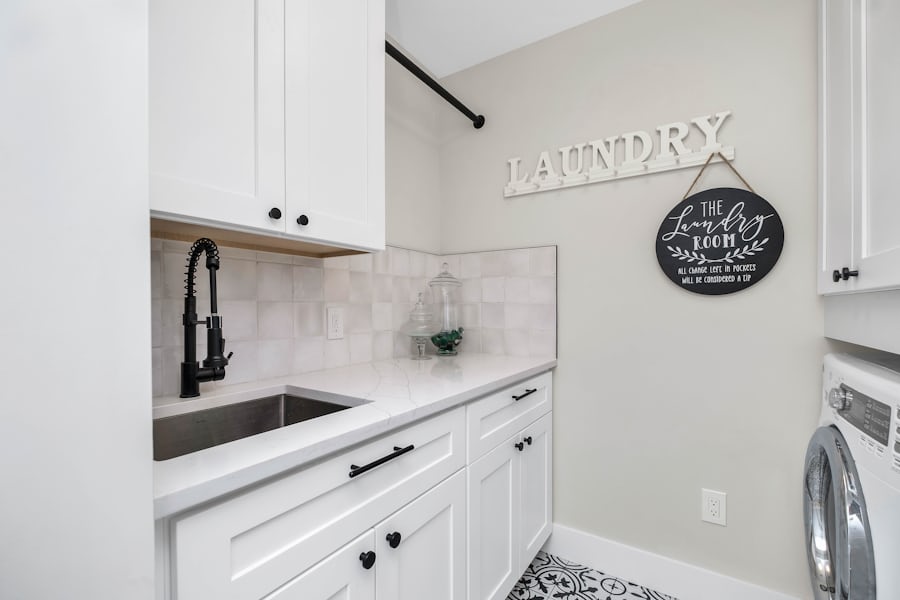 Practical laundry room with Whirlpool-style washer and utility sink